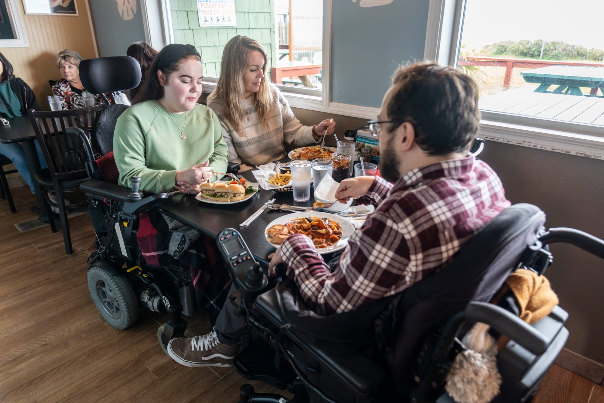 Wheelchair-users enjoying food at an accessible restaurant in Tillamook Coast, Oregon