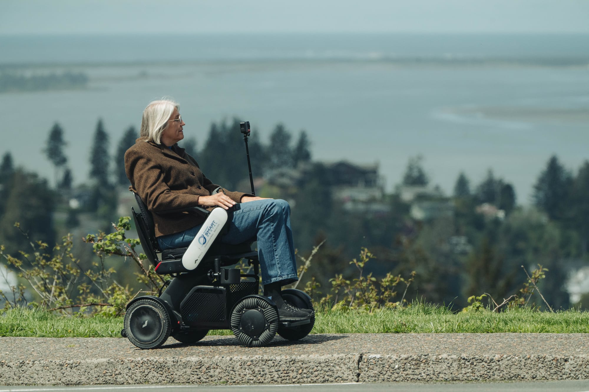 Power wheelchair user overlooking Astoria, Oregon on accessible paths