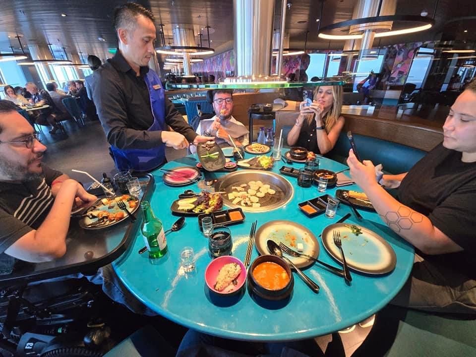 Cory Lee and group enjoying a meal on the Virgin Voyages cruise