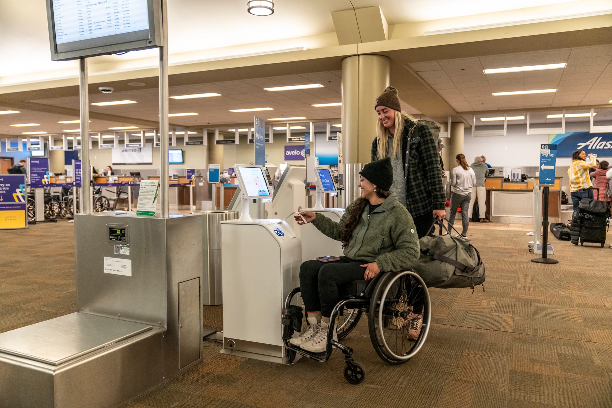 Wheelchair user and companion navigating the airport in Oregon