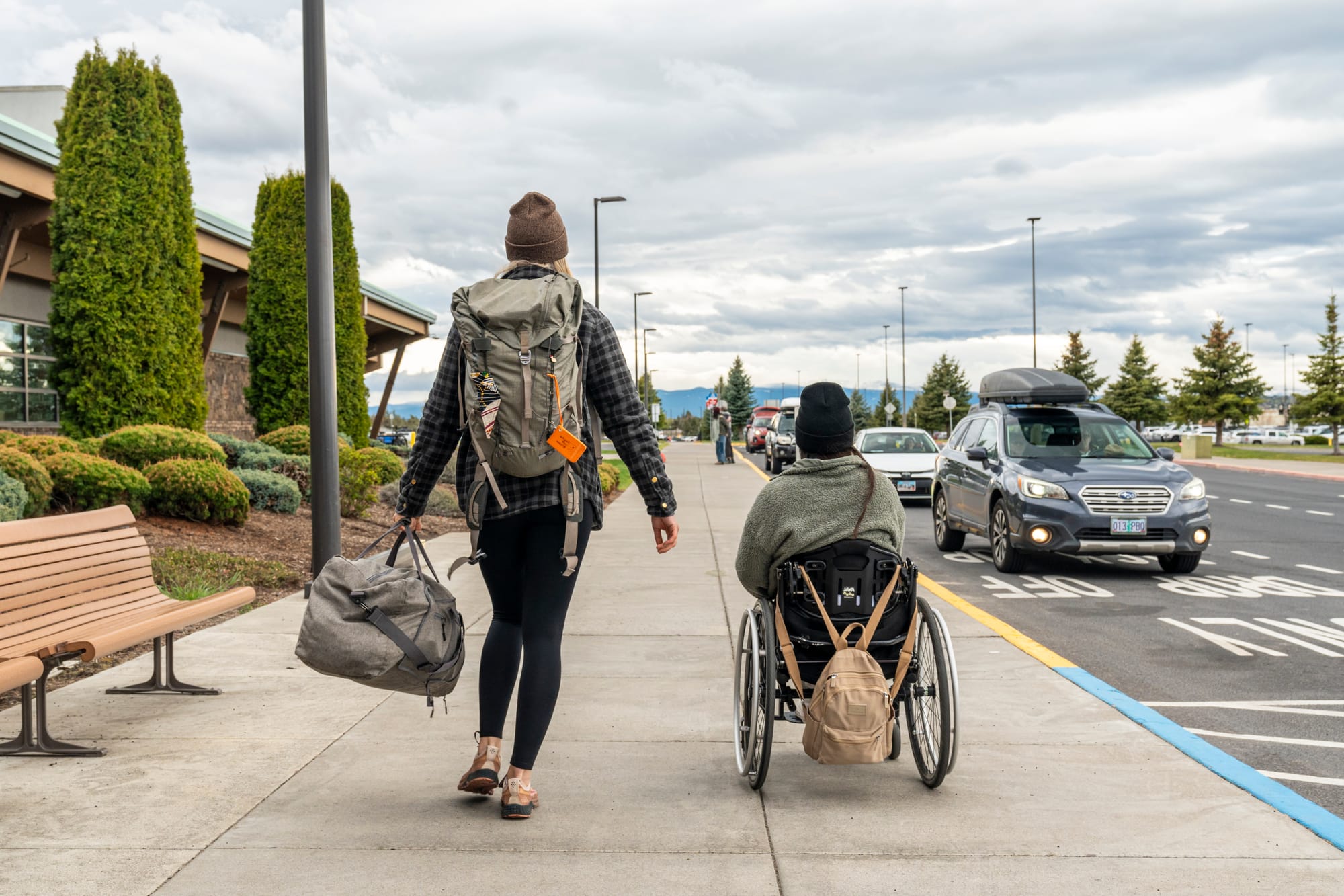 Wheelchair user and companion getting picked up at the airport
