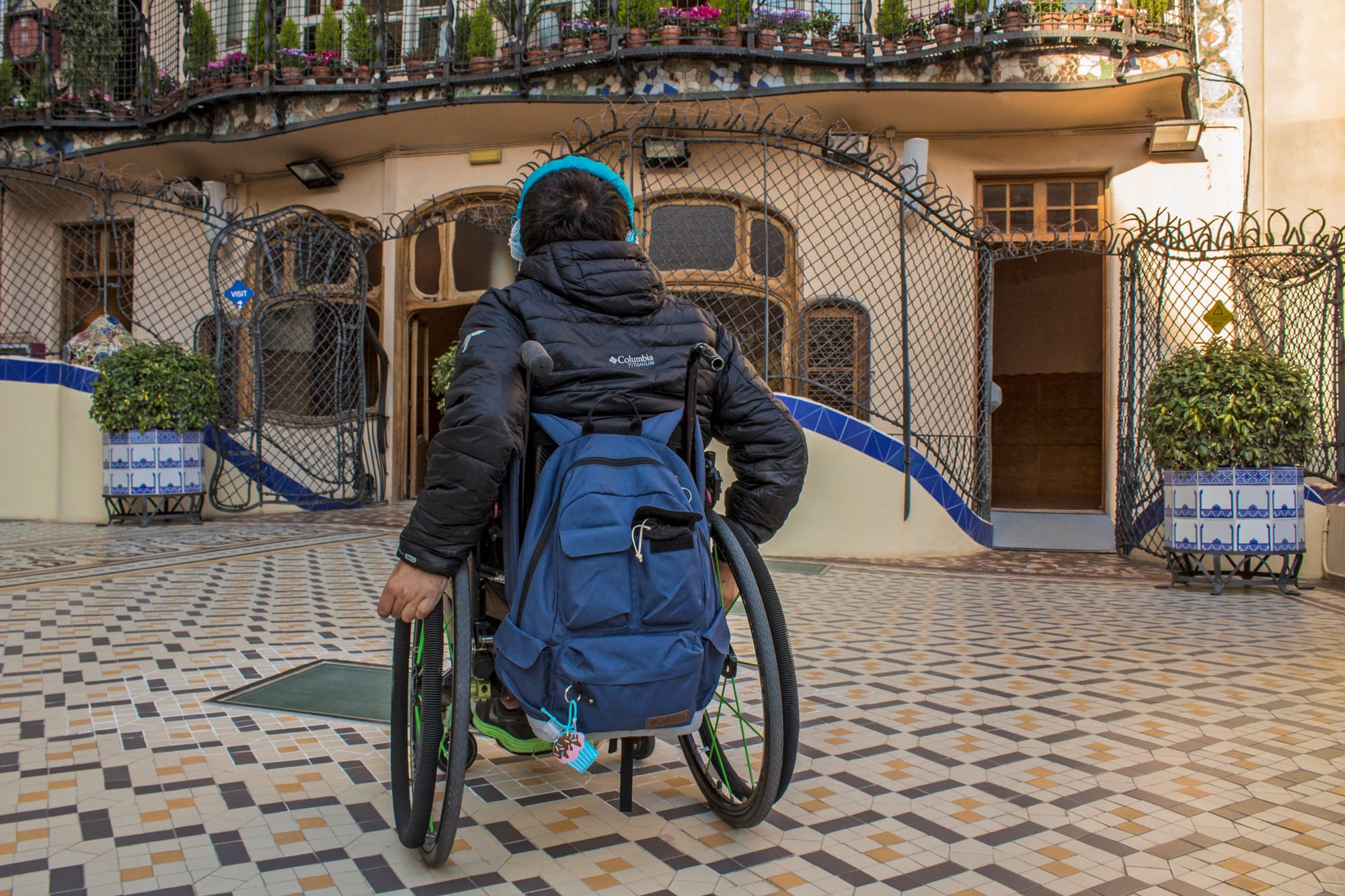 Wheelchair user in front of a Gaudi building in Barcelona