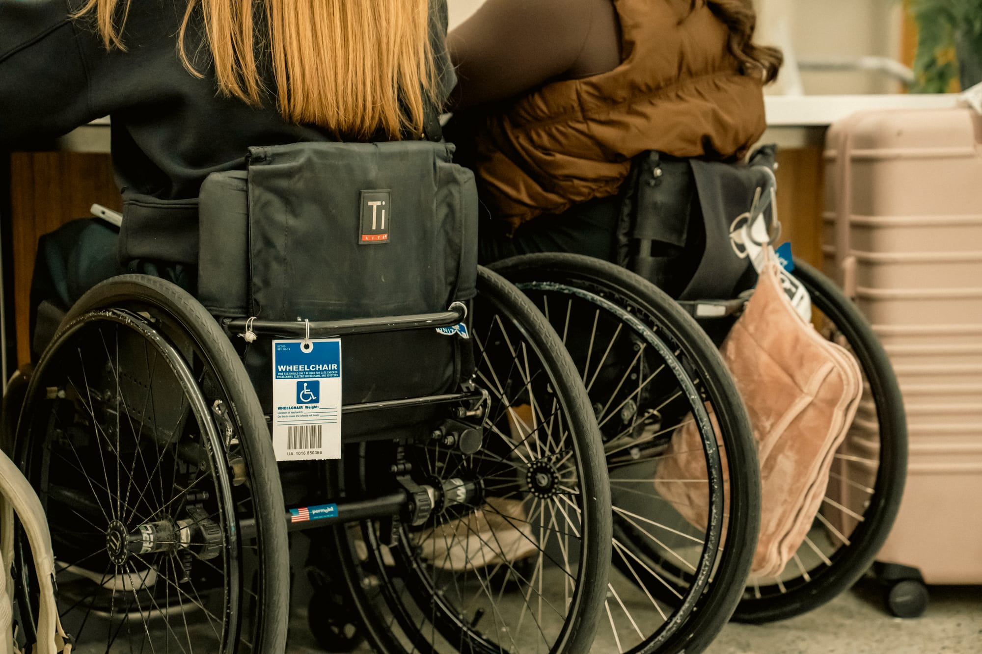 Wheelchair users with airport tag on their chairs