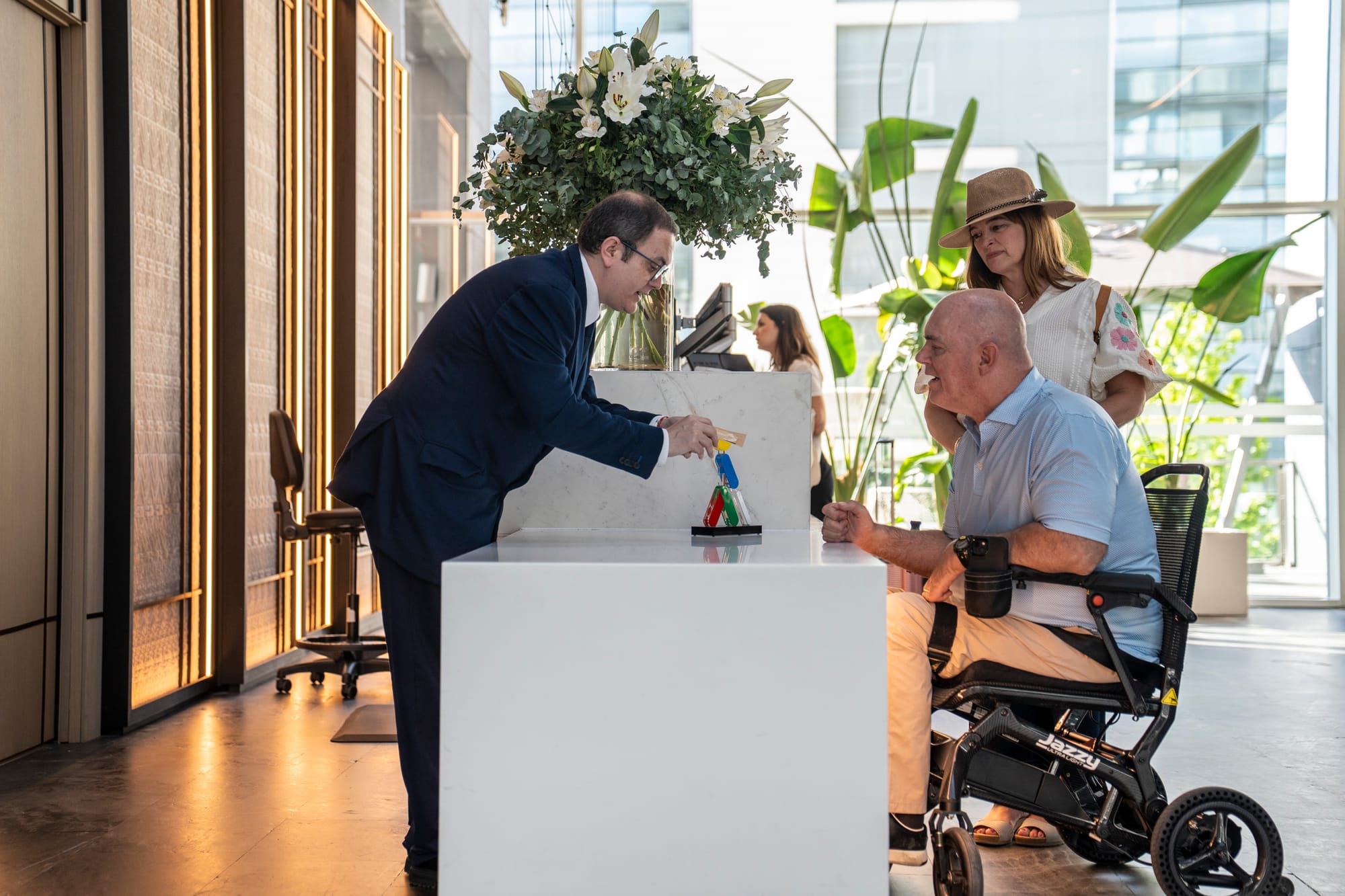 Front lobby, wheelchair user and companion checking in at Ilunion Atrium
