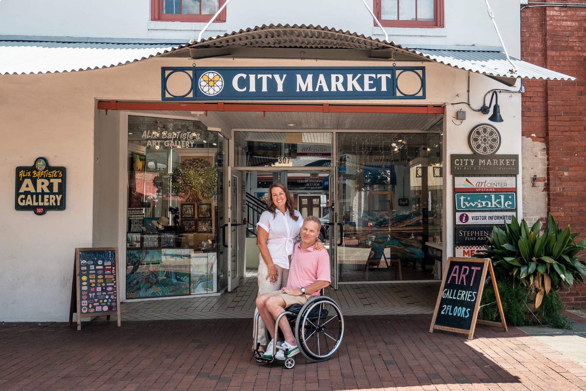Wheelchair user and companion in front of City Market in Savannah, an accessible attraction