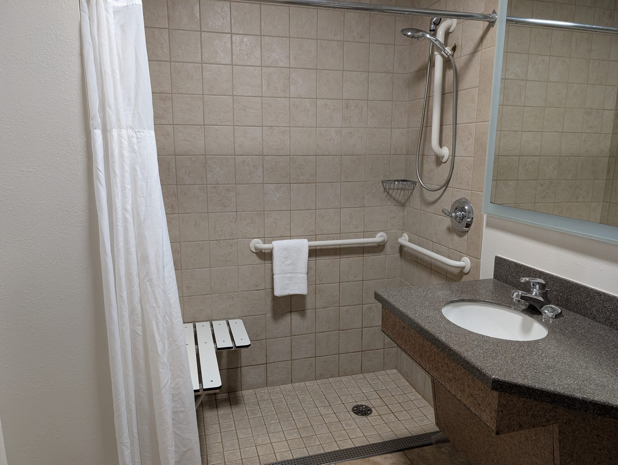 Roll-in shower, grab bars and seat at The Lux Hotel & Conference Center in Seneca Falls