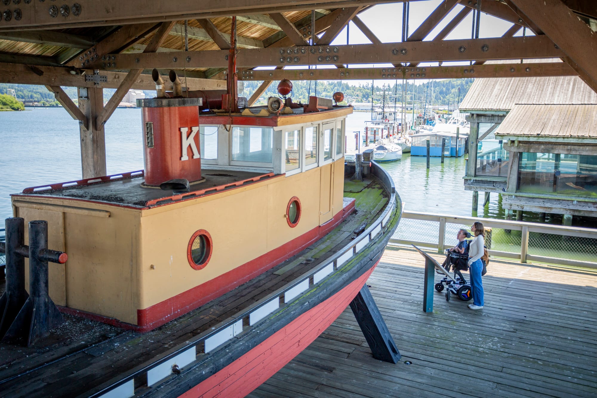 Squirmy and grubs looking at the wooden boat along the Coos Bay boardwalk