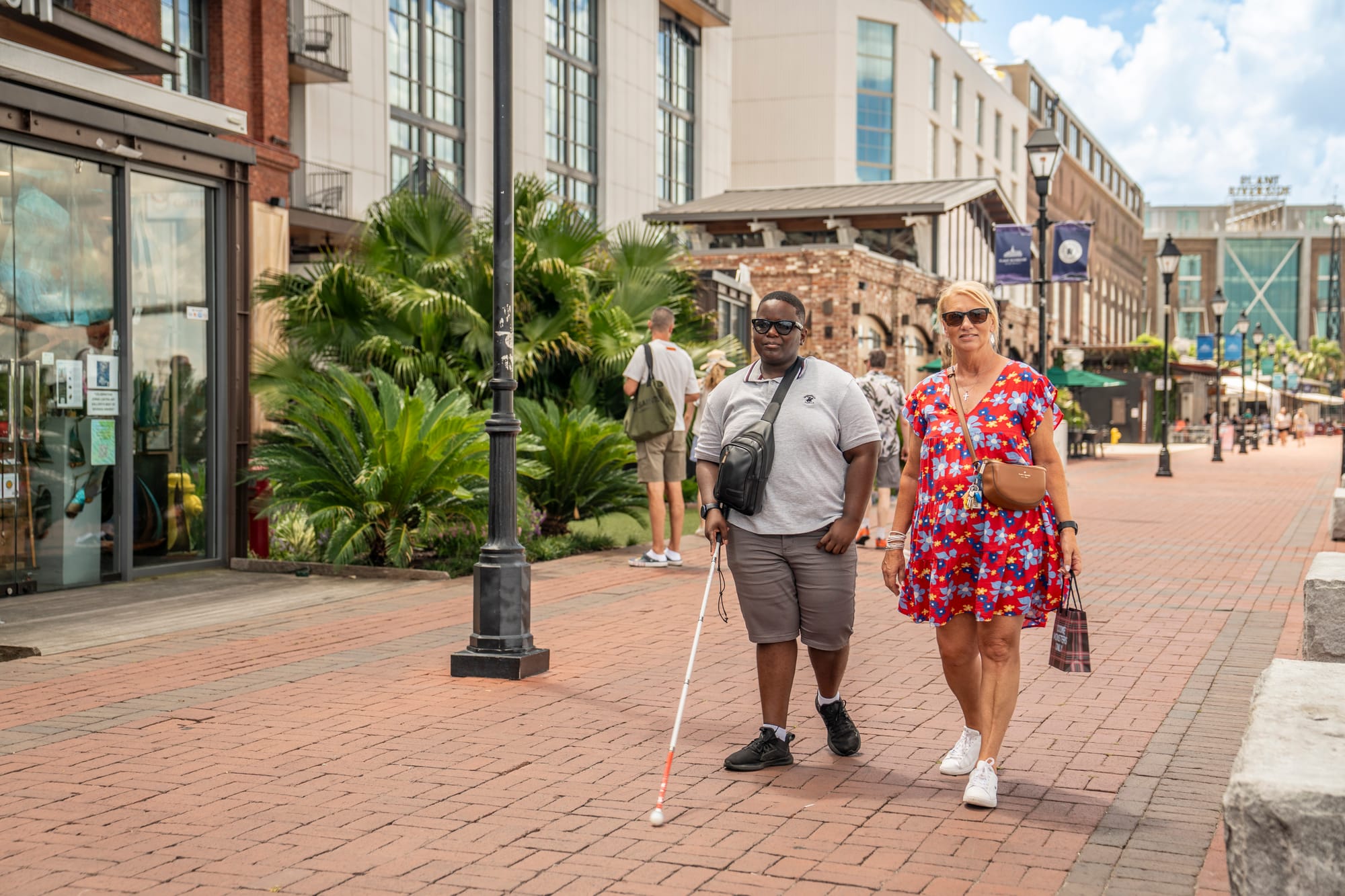 Blind person and companion strolling along the riverfront in Savannah