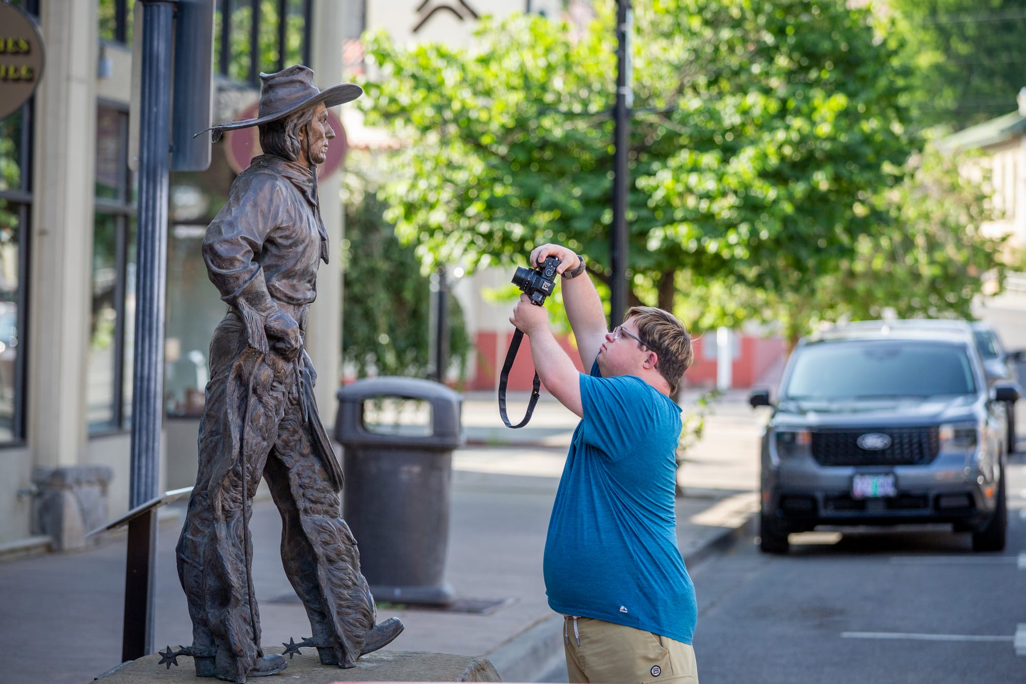 Houston, man with down syndrome, taking photo of statue in downtown Pendleton