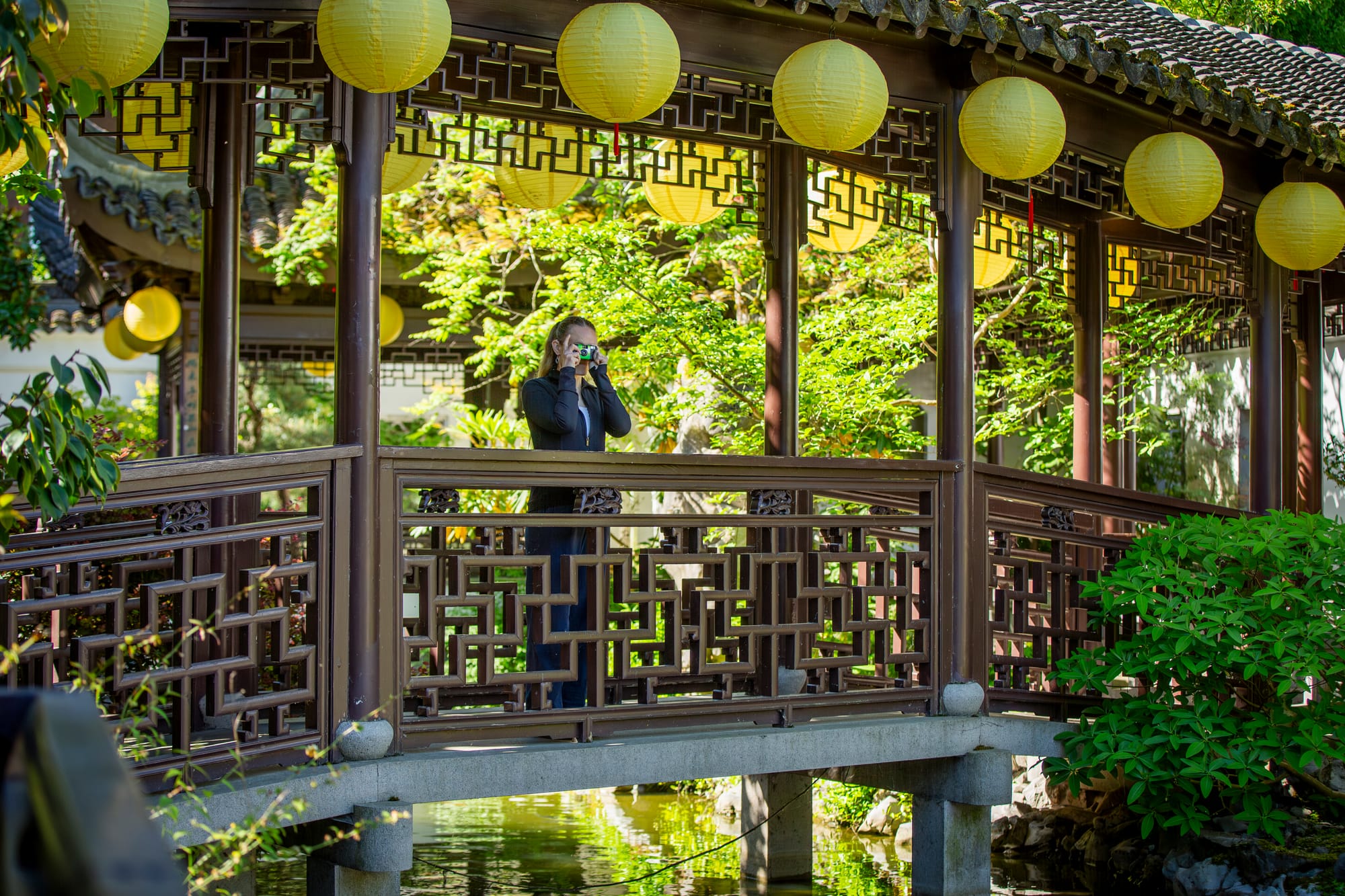 Lady snapping a photo at Lan Su Chinese Garden