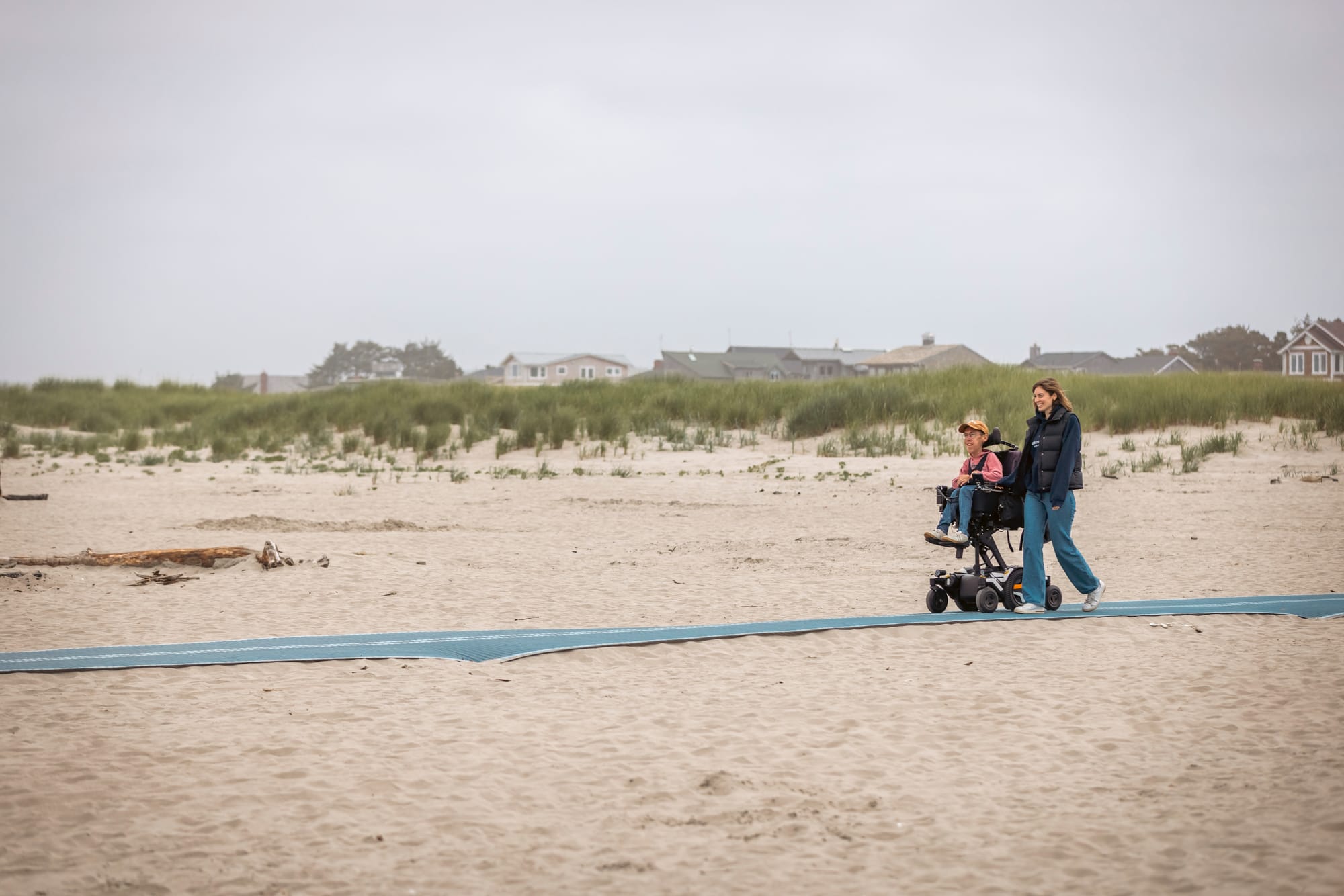 Shane Burcaw, a wheelchair user, and his wife Hannah, on an accessible mobi mat in Seaside, Oregon