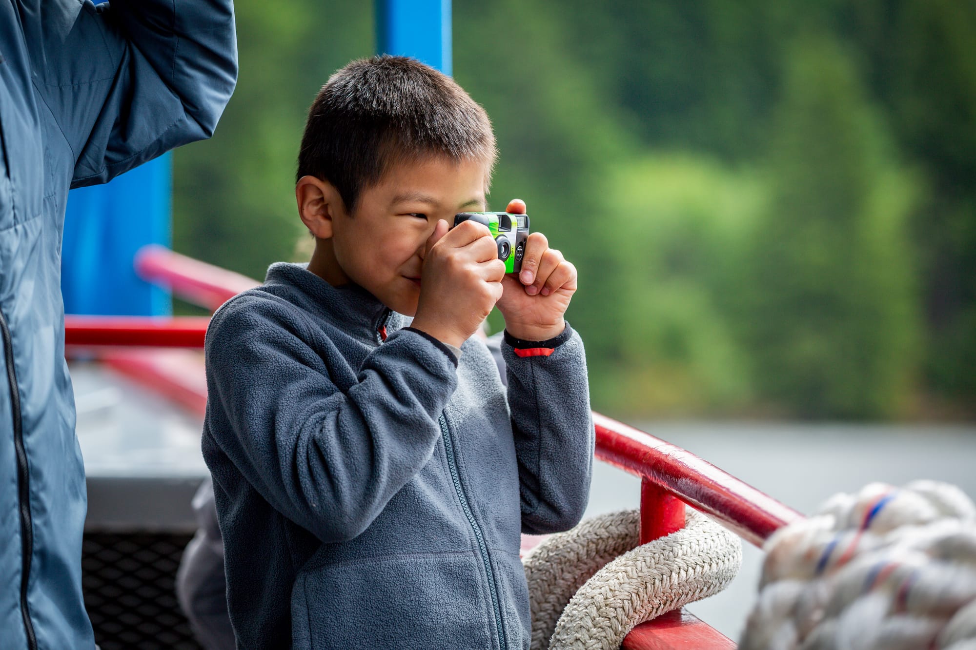 Boy snapping photo with disposable camera from the Sternwheeler Columbia Gorge