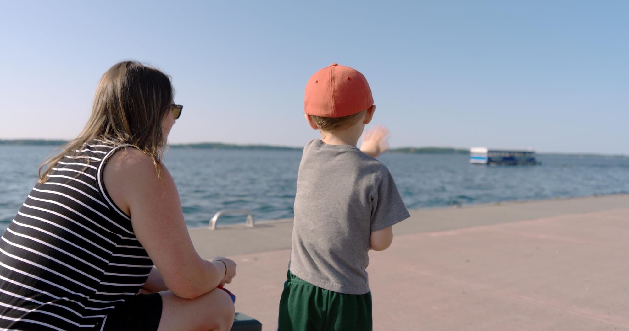 Boy and mom waving at a boat tour in 1000 Island, NY