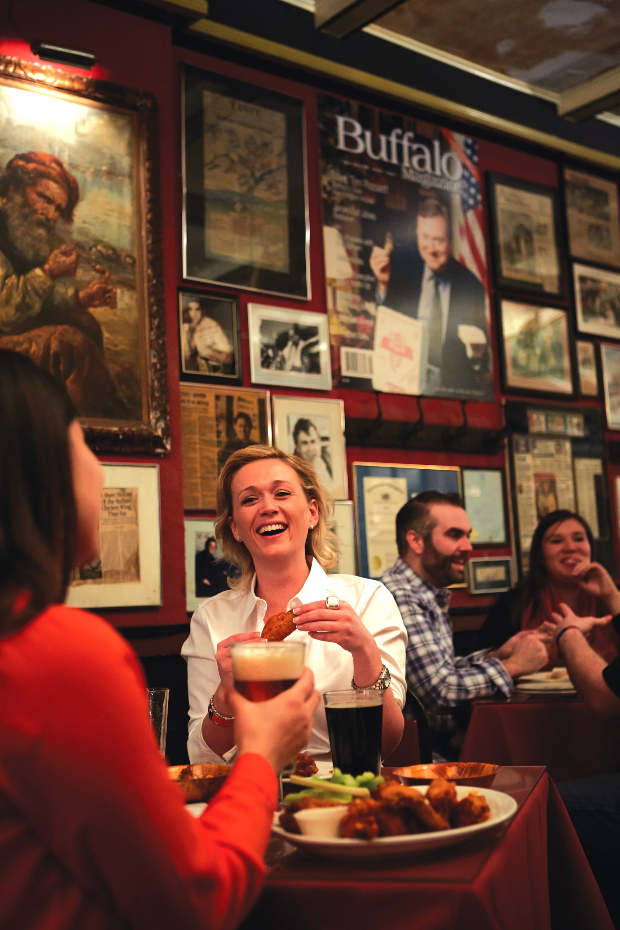 Woman laughing and enjoying wings at Anchor Bar in Buffalo