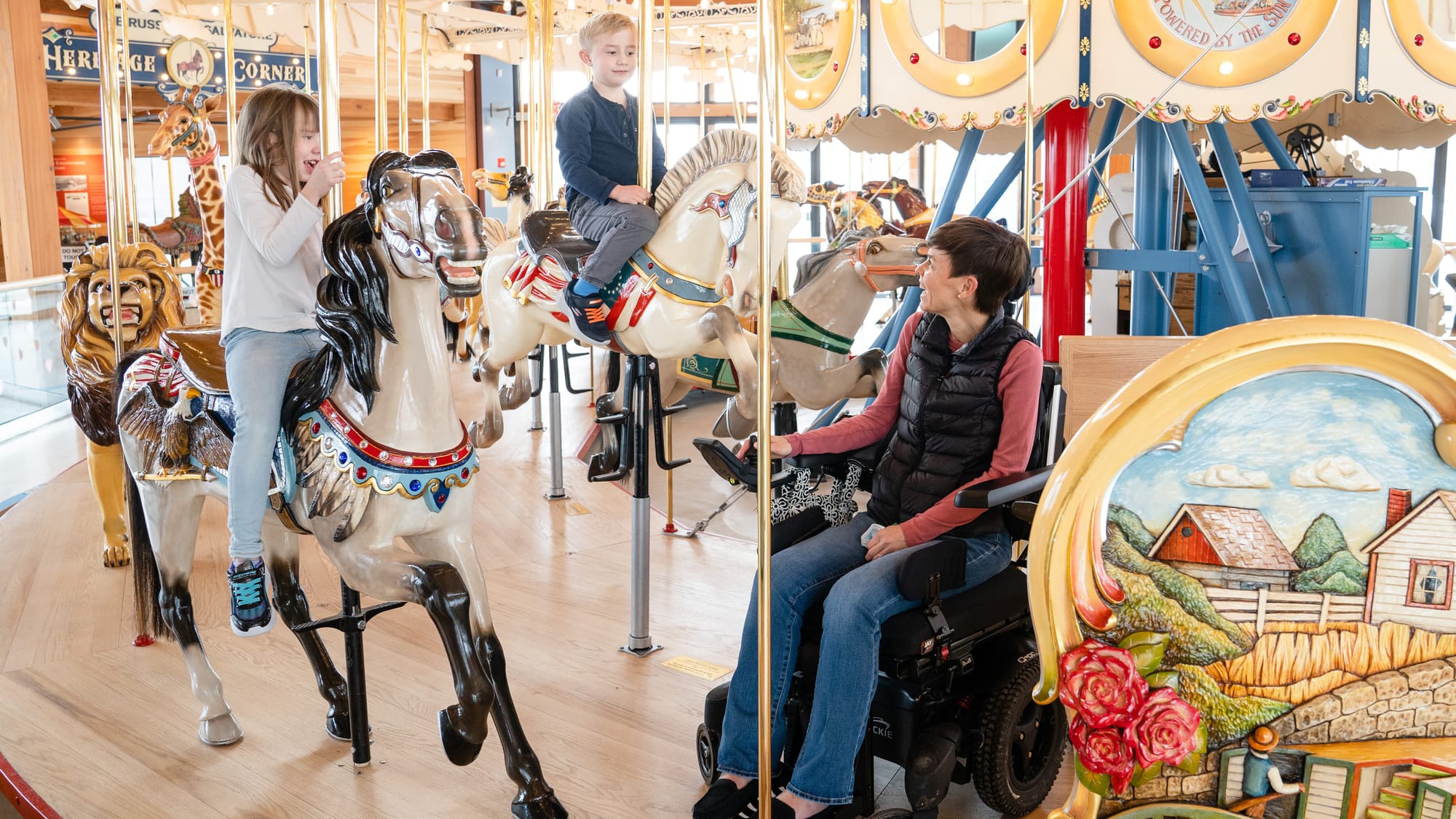 Wheelchair user watching children on the canalside carousel in Buffalo