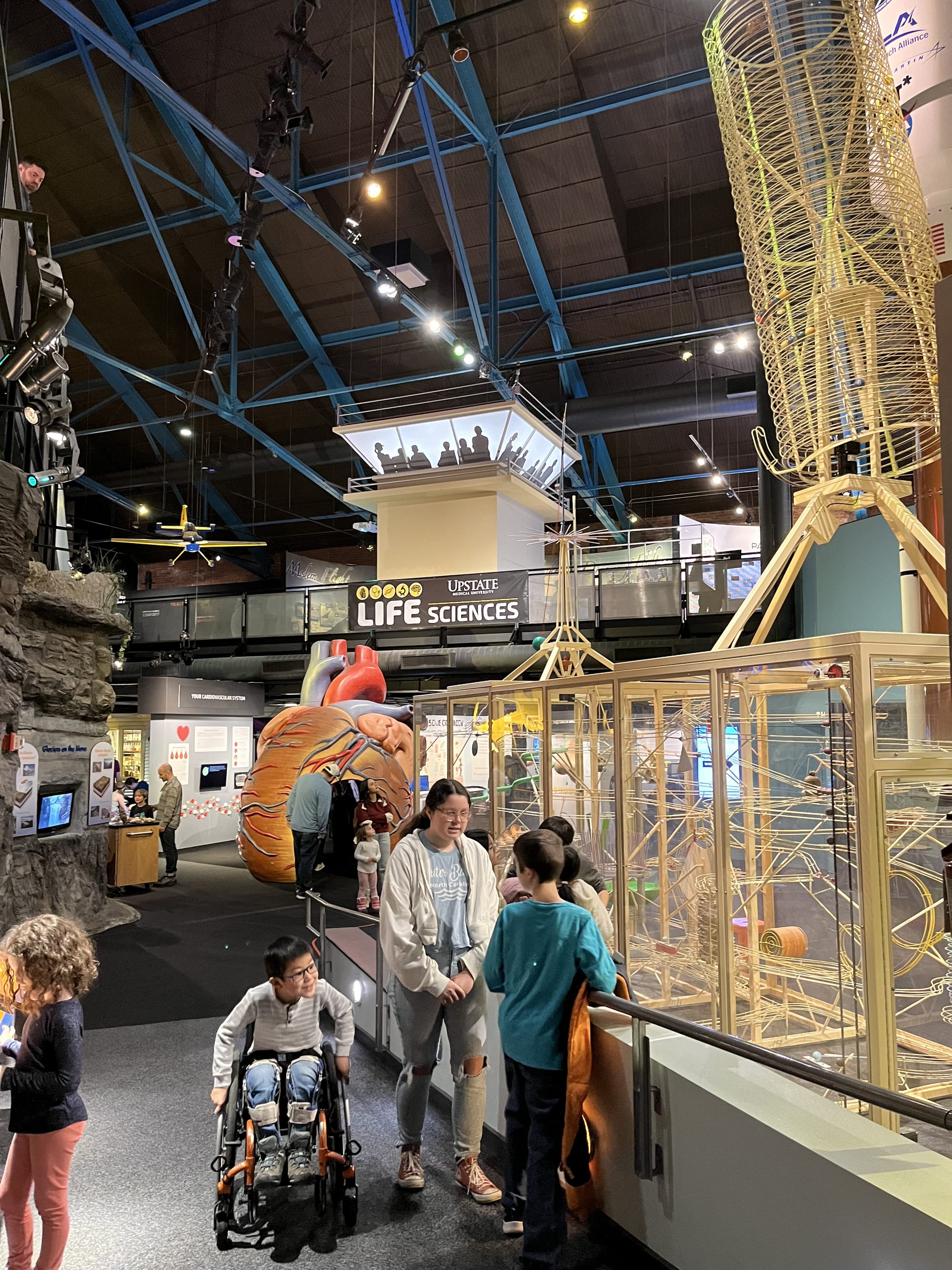 Wheelchair user and friends checking out exhibits at Museum of Science & Technology in Syracuse