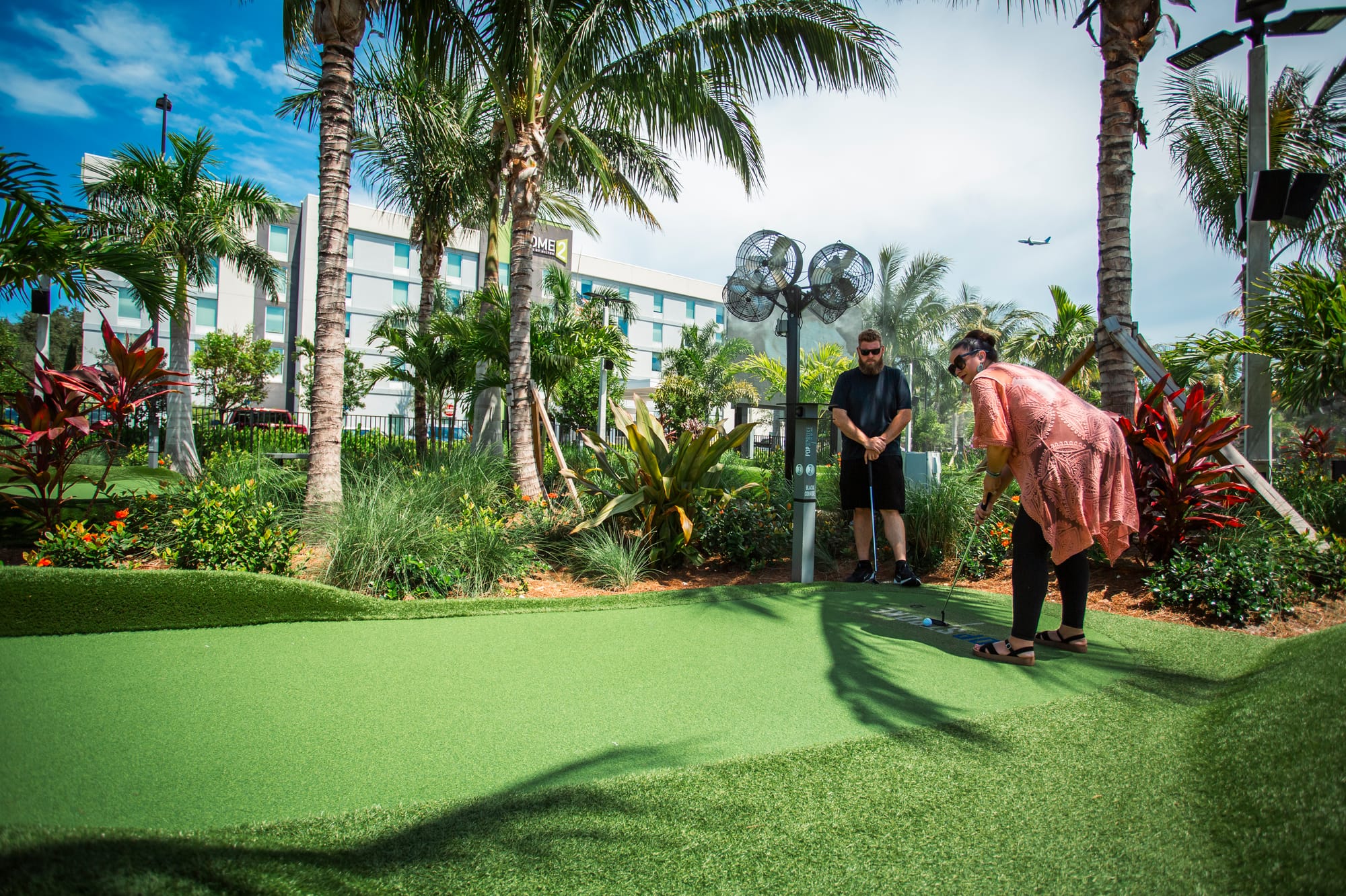 Couple enjoying PopStroke mini golf in Palm Beaches