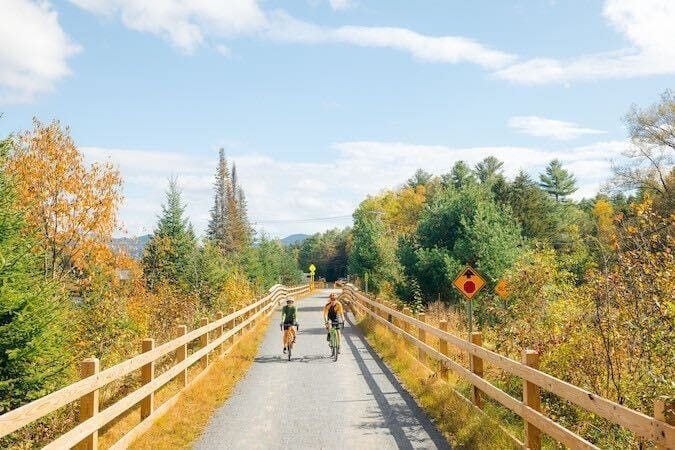 Bikers riding the Adirondack Rail Trail with fall foliage colors