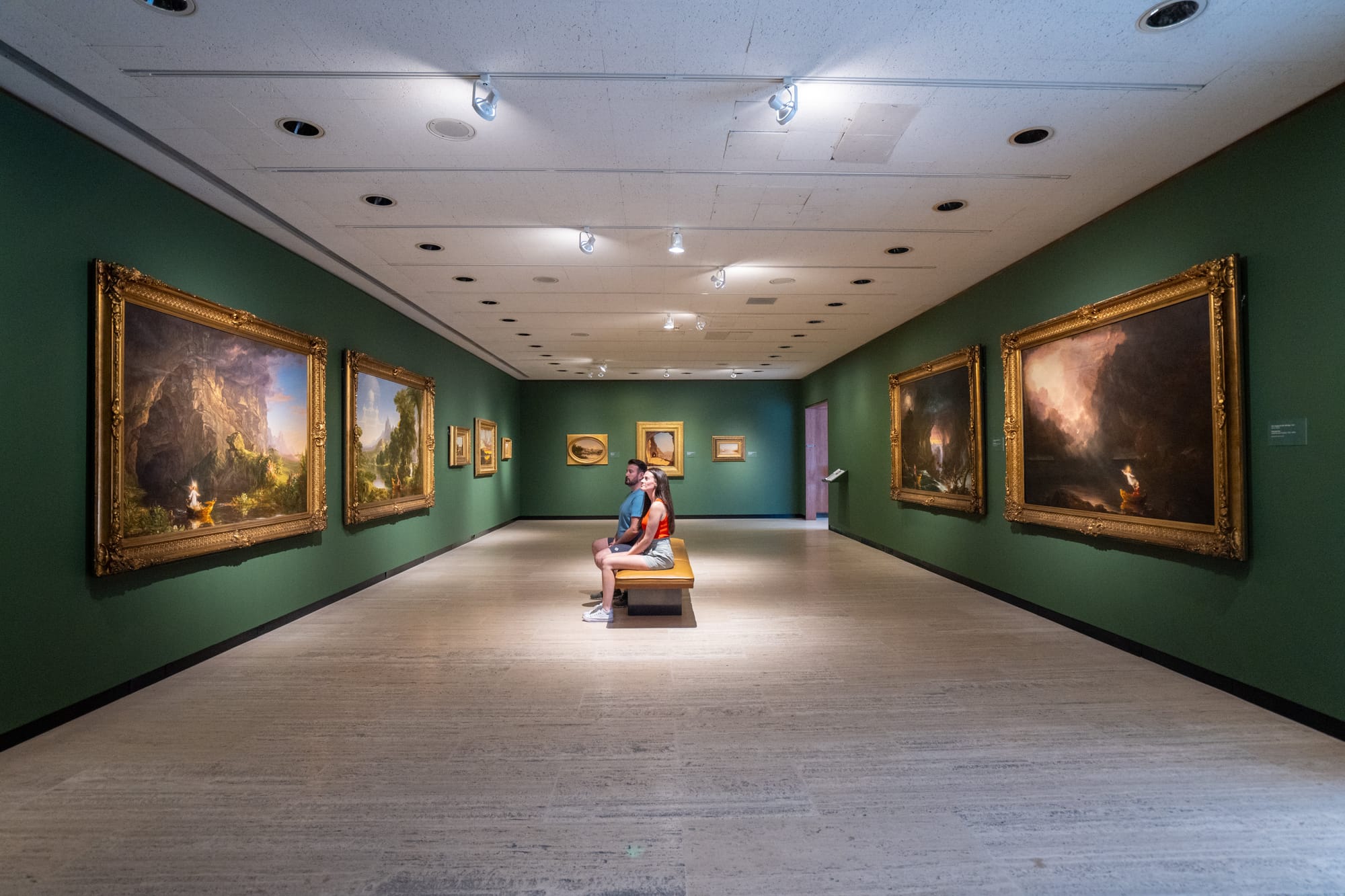 Couple sitting on bench viewing art at Munson in Utica, NY