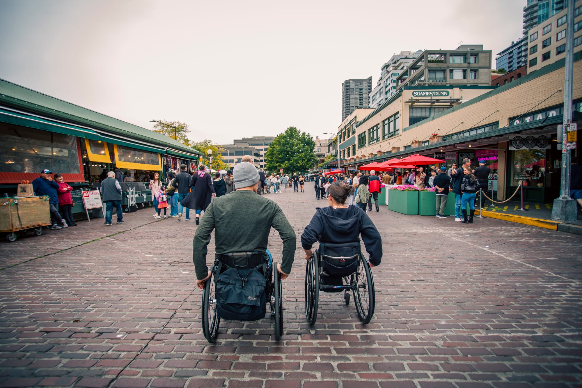 Maggie and Brad, two wheelchair users, exploring Pike Place Market