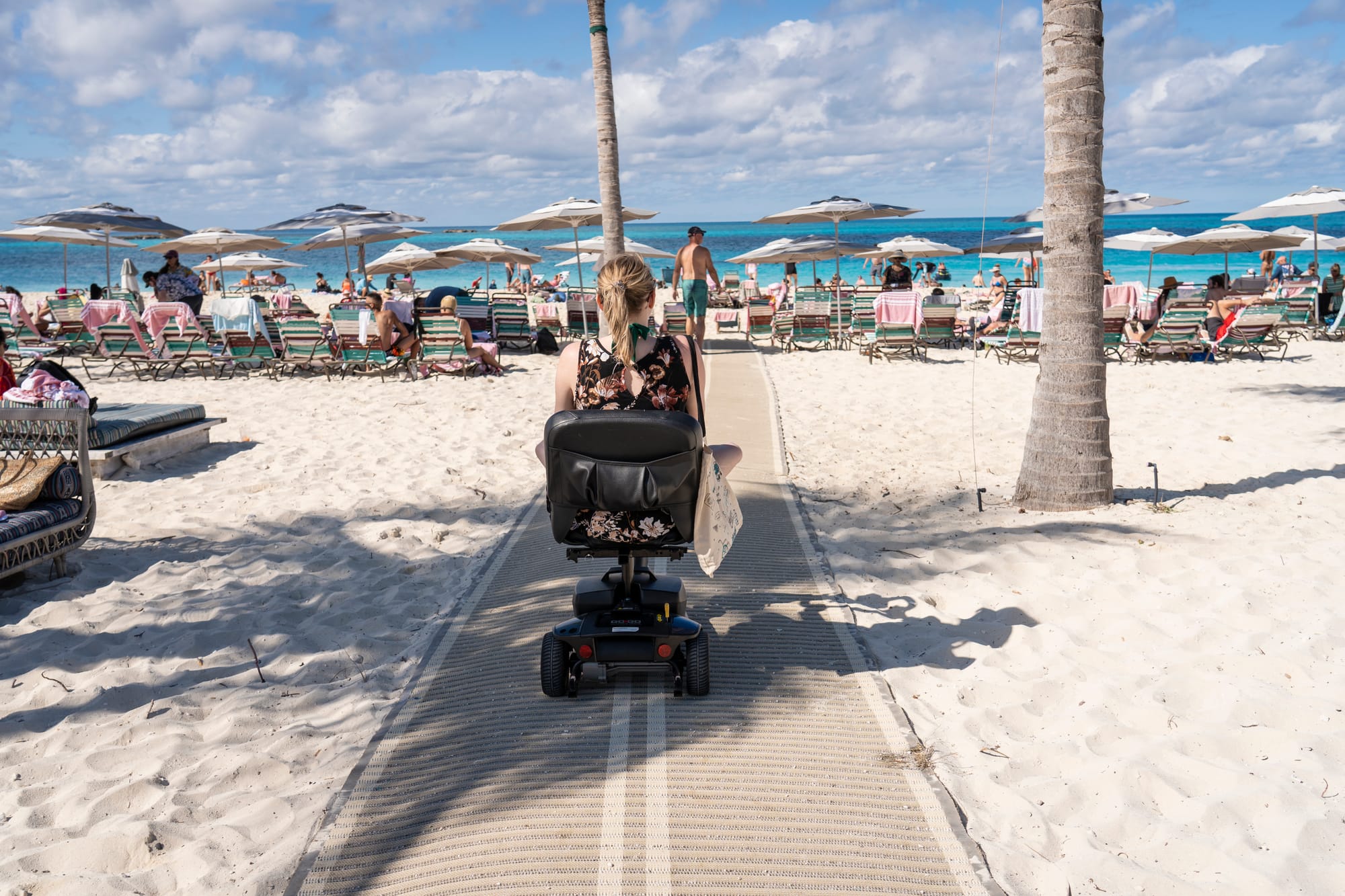 Anna Schmid, wheelchair user, on beach mobi mat on a cruise port stop with Virgin Voyages