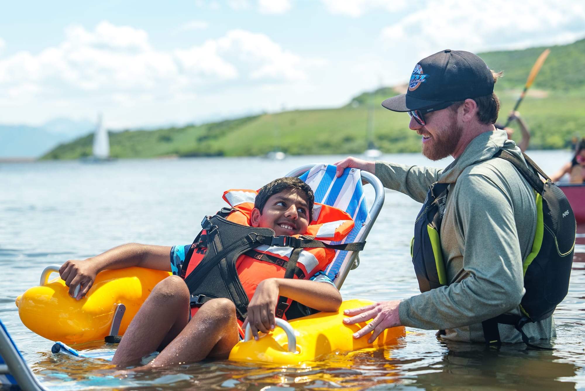 Boy with physical disability sitting in an accessible floating chair in the lake