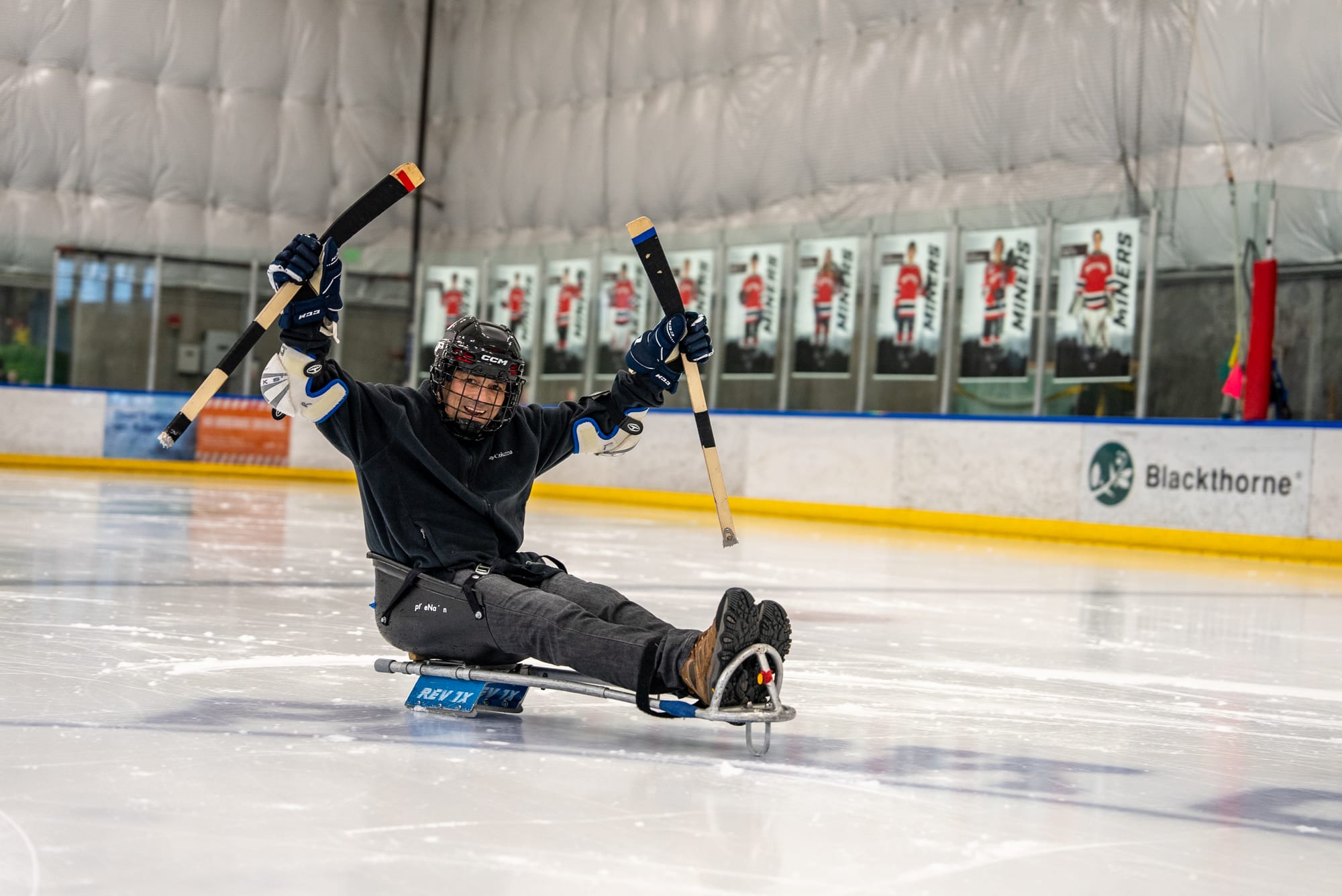 Man on a sit-sled on an ice rink, a way of adaptive skating 
