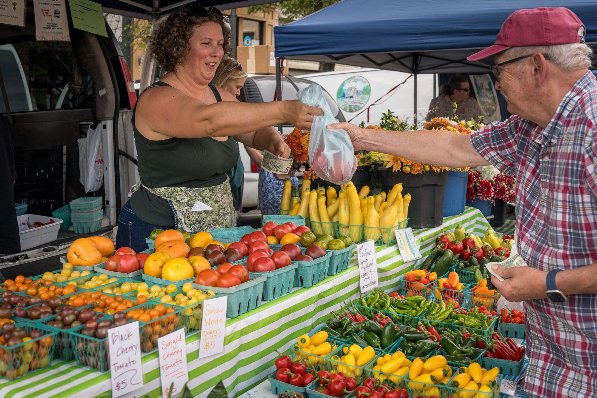 Man purchasing produce from a vendor at the Farmers Market