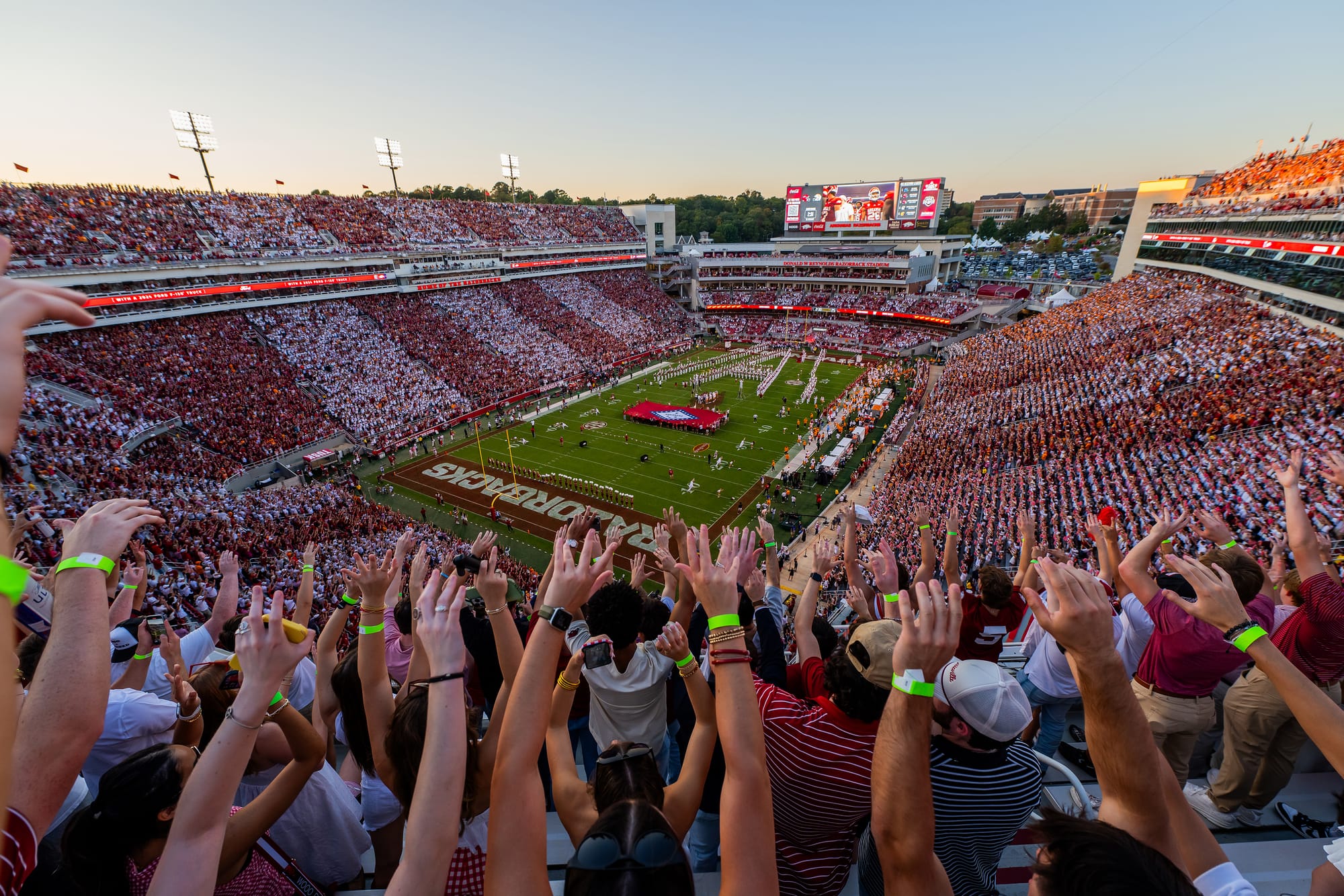 Football fans raising their hands in Razorback Stadium