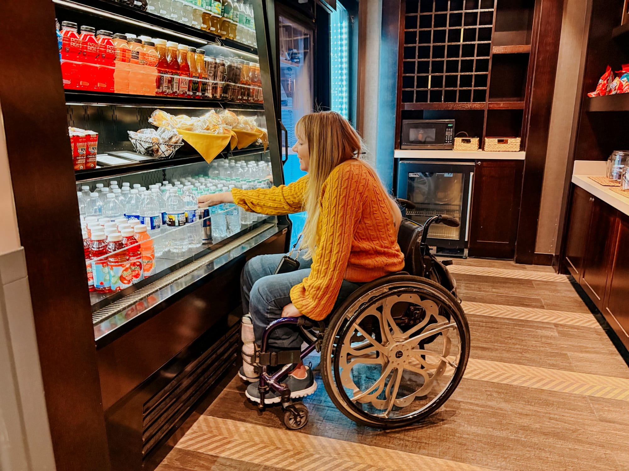 Wheelchair user in a little shop grabbing a water bottle