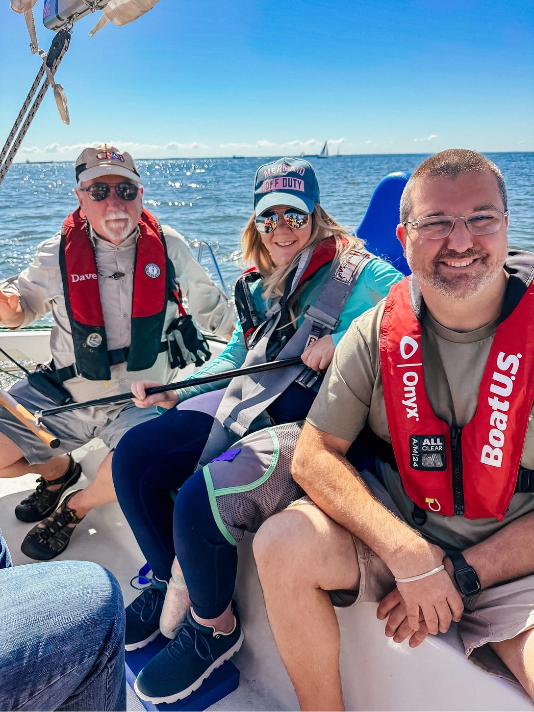Wheelchair user trying adaptive sailing with her husband and instructor