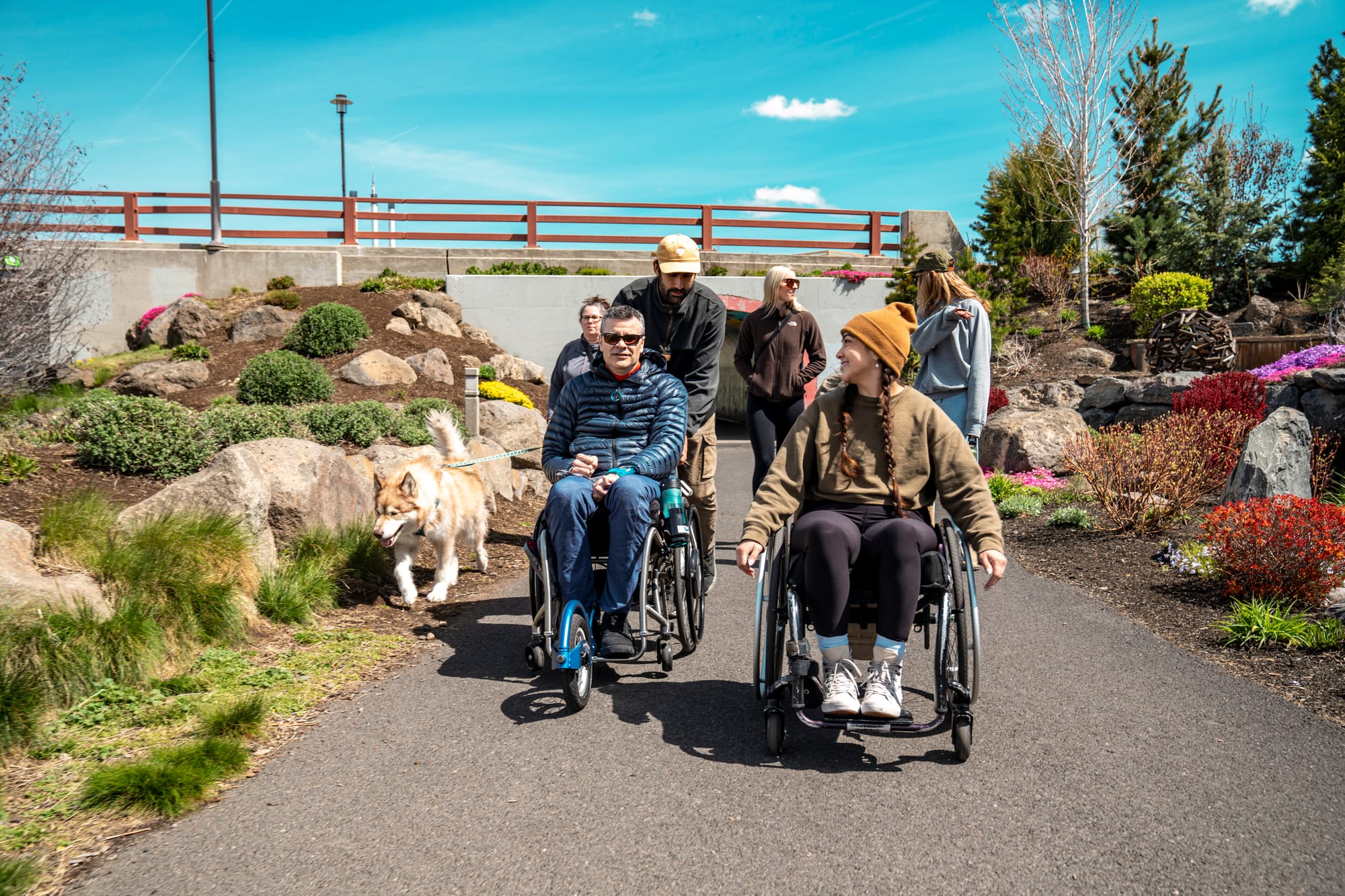 Wheelchair users and companions exploring riverfront trail in Bend, Oregon