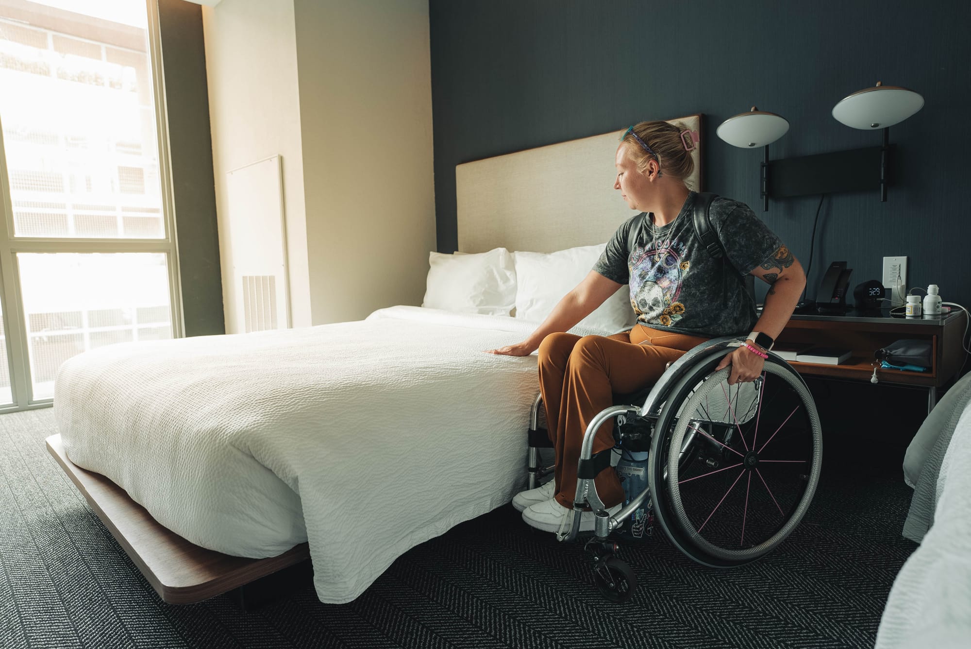 Wheelchair user next to a low, accessible bed height