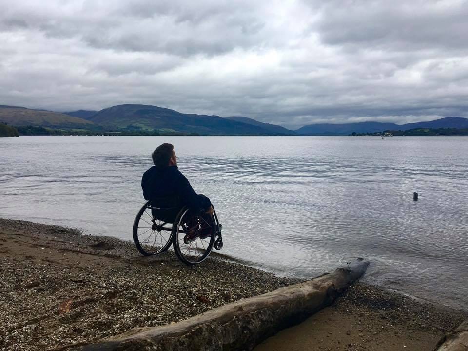 Anthony, wheelchair user, at the edge of the lake looking out