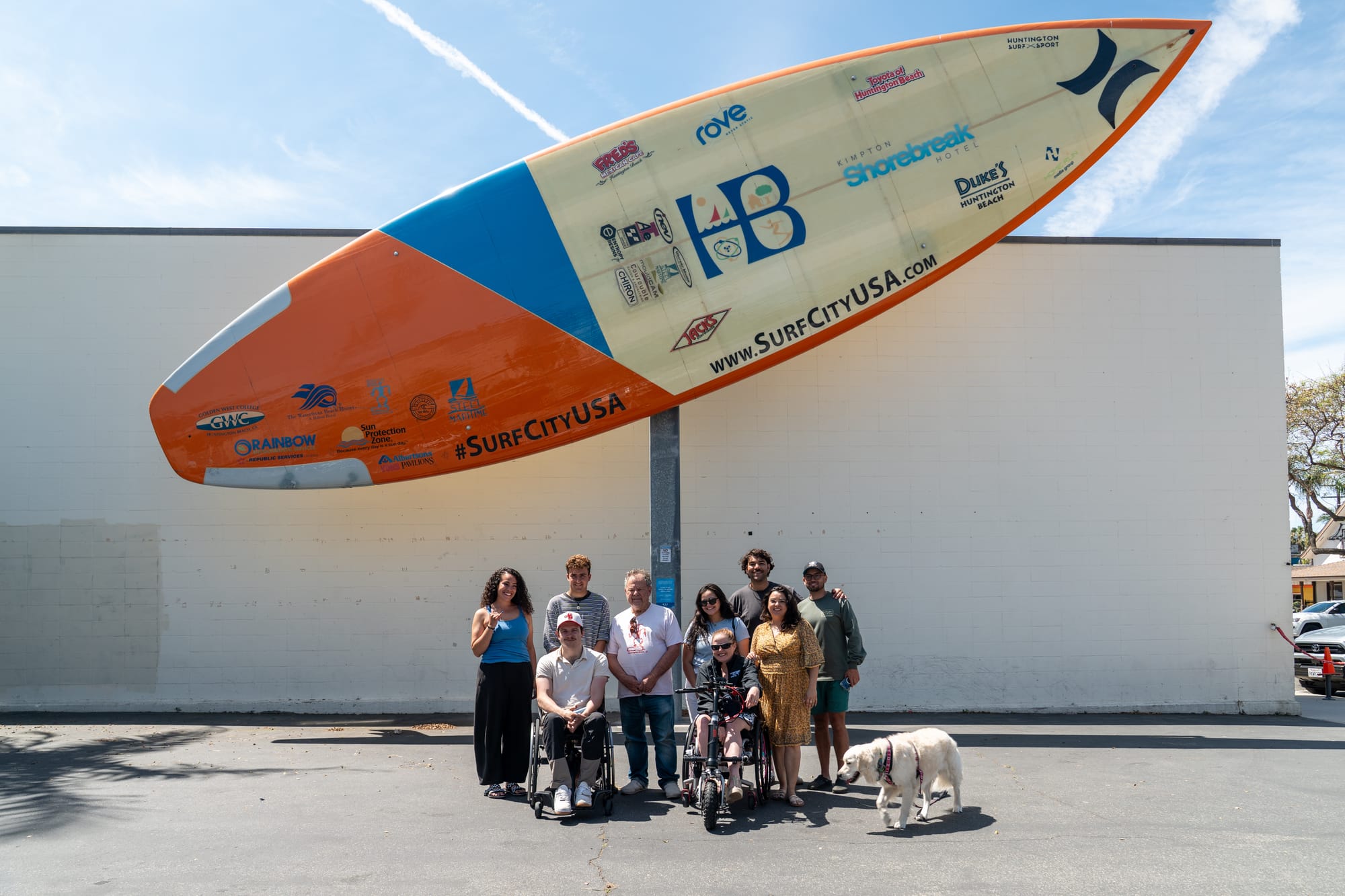 Travelers outside in front of the big surfboard at Huntington Beach International Surfing Museum
