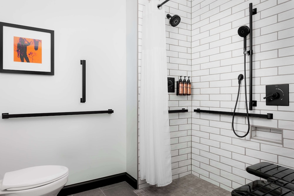 Roll-in shower with a bench at Motto by Hilton Bentonville Downtown