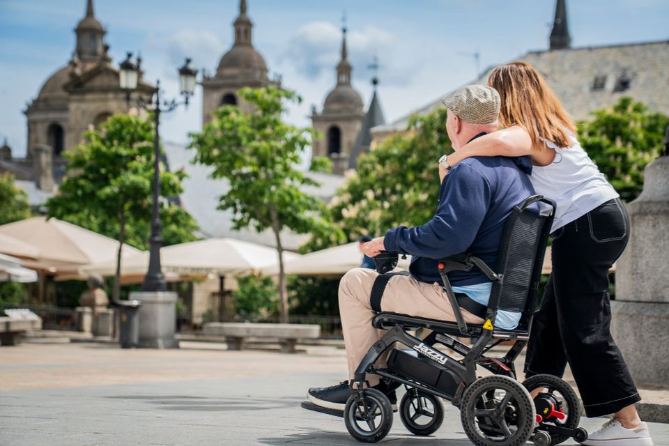 Man in travel power wheelchair with his wife in Madrid