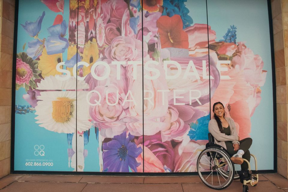 Kerry, wheelchair user, in front of the Scottsdale Quarter mural in Scottsdale, Arizona