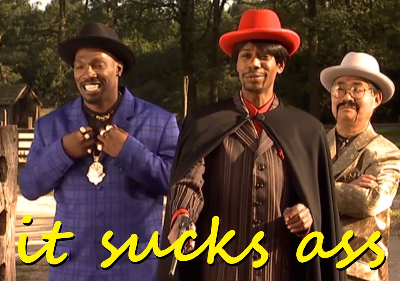 Dave Chappelle in his iconic Haters skit, the subtitle reading in cursive: it sucks ass.