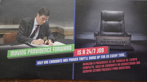 Mailpiece featuring Providence Mayor Brett Smiley at left, seemingly signing legislation, and an empty, cobwebbed chair at right with a placard reading “Representative David Morales”.