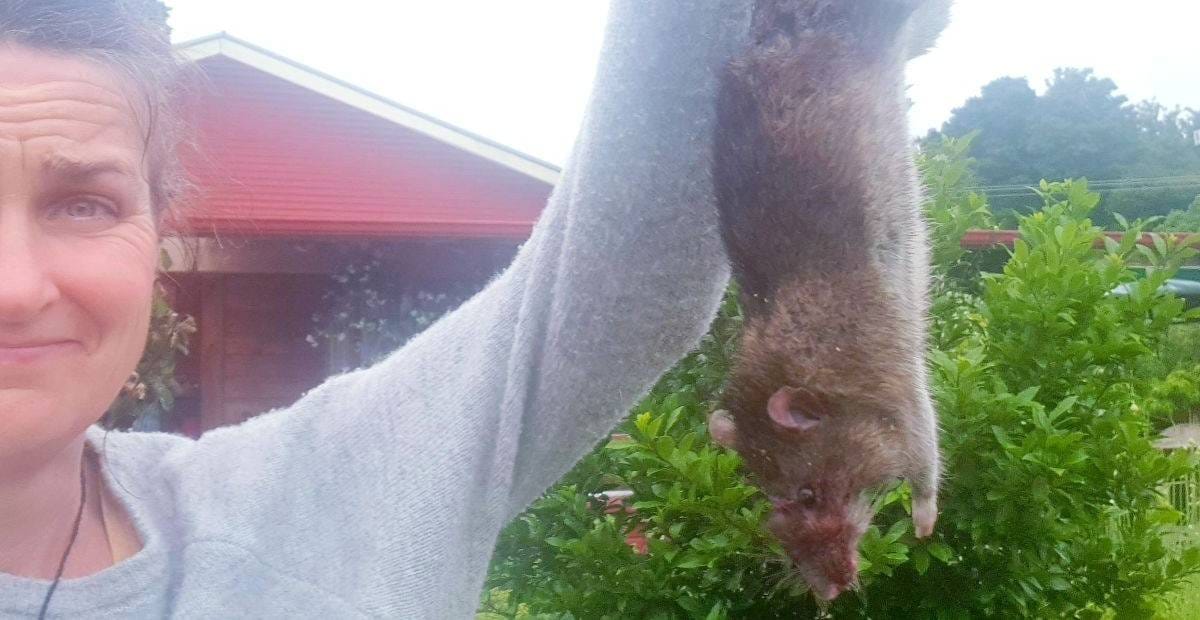 Kath holding a rat she caught in a trap