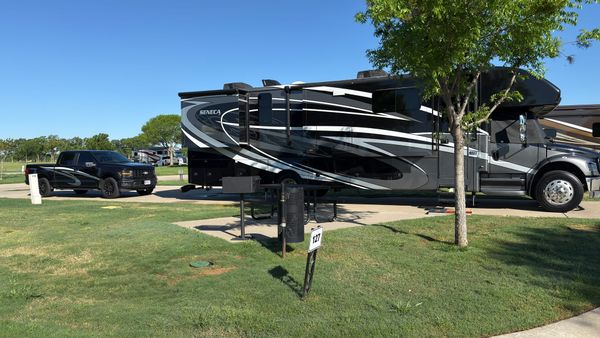 Harriet, a large Super C motorhome, parked beside Vern at a grassy RV site in Thackerville, Oklahoma.