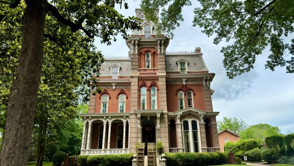 Red-brick Victorian mansion with a central tower and ornate porch in Memphis’ Victorian Village.