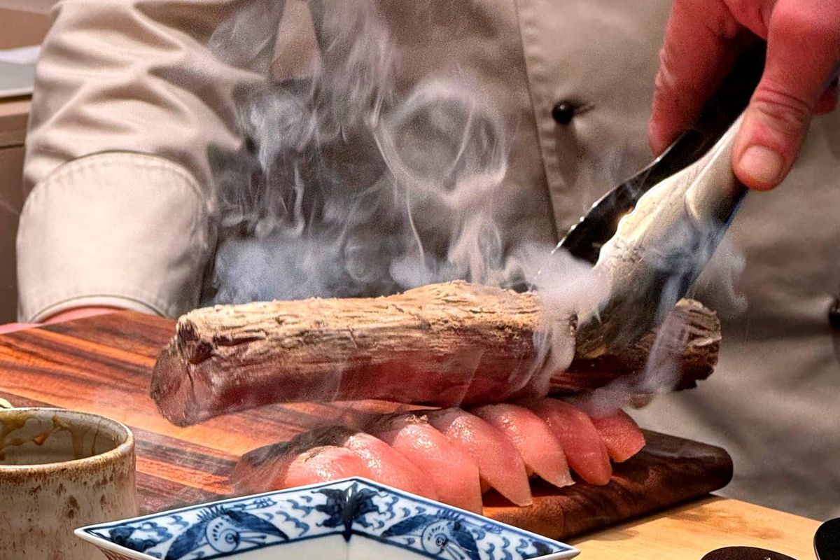 The final gesture before service: toro touched by binchotan, then served immediately.