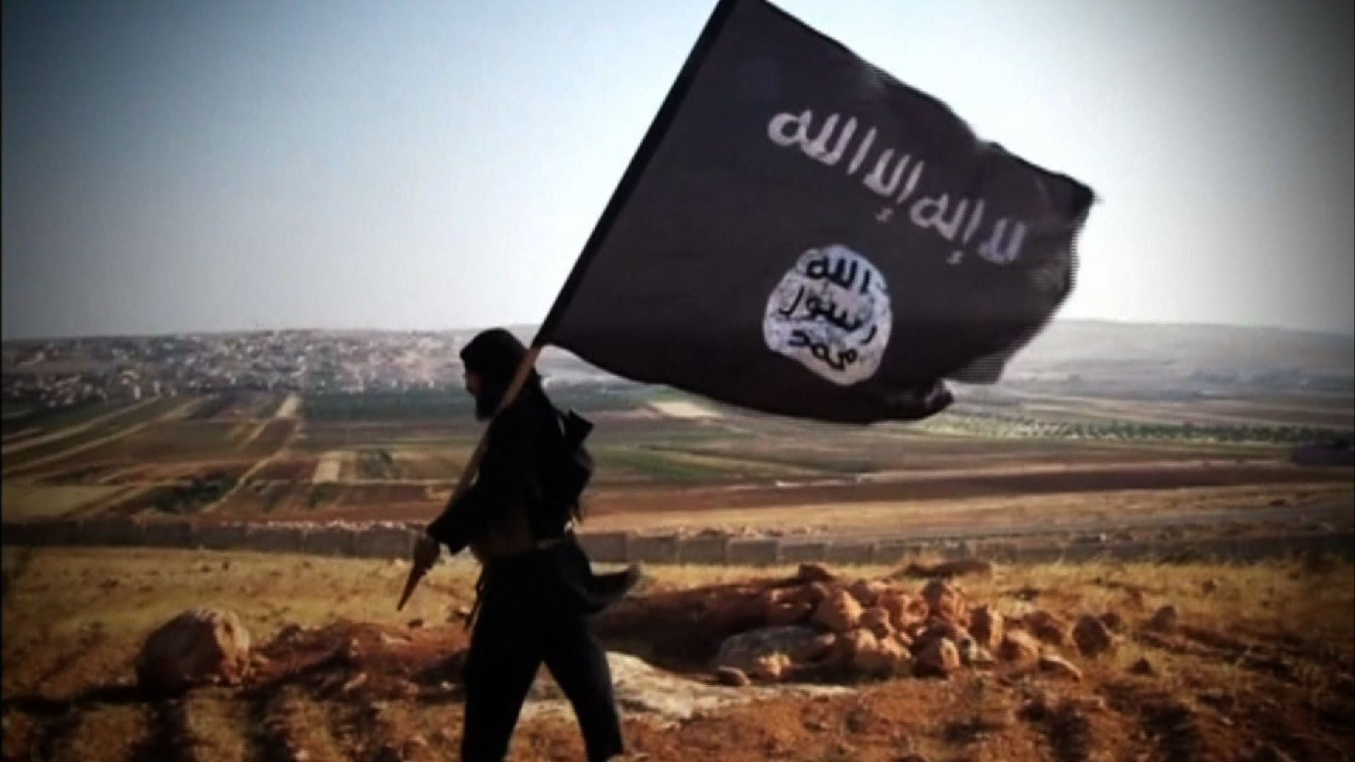 A member of ISIS carries the group's flag