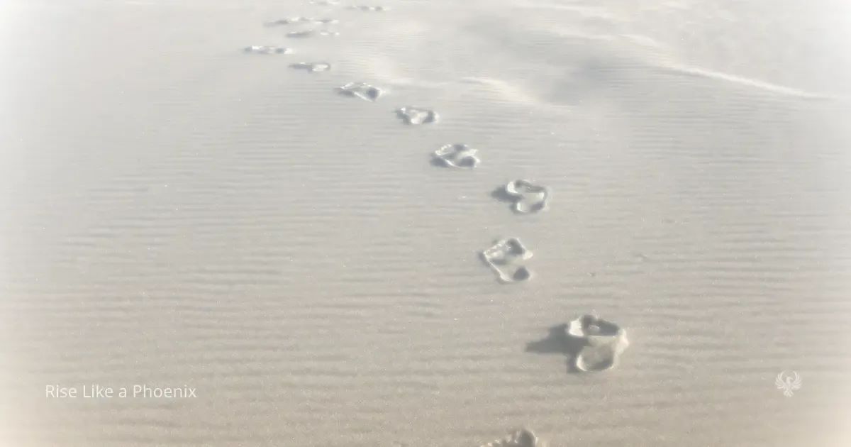 Footprints in sand forming a single path, symbolizing choice, continuity, and the consequences of past actions.
