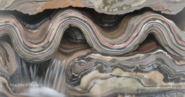 Layered rock formation with flowing water symbolizing structure, conditioning, and individual response.
