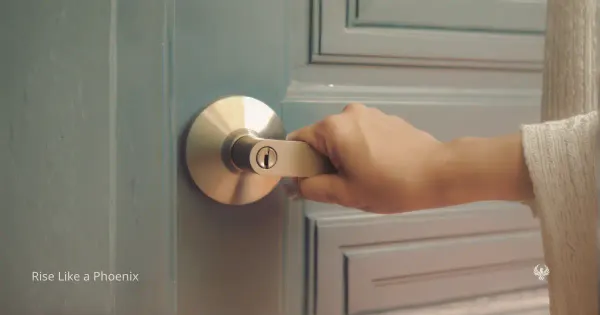 A close-up image of a hand holding a door handle on a soft blue door, symbolizing boundaries, access, and discernment in relationship.