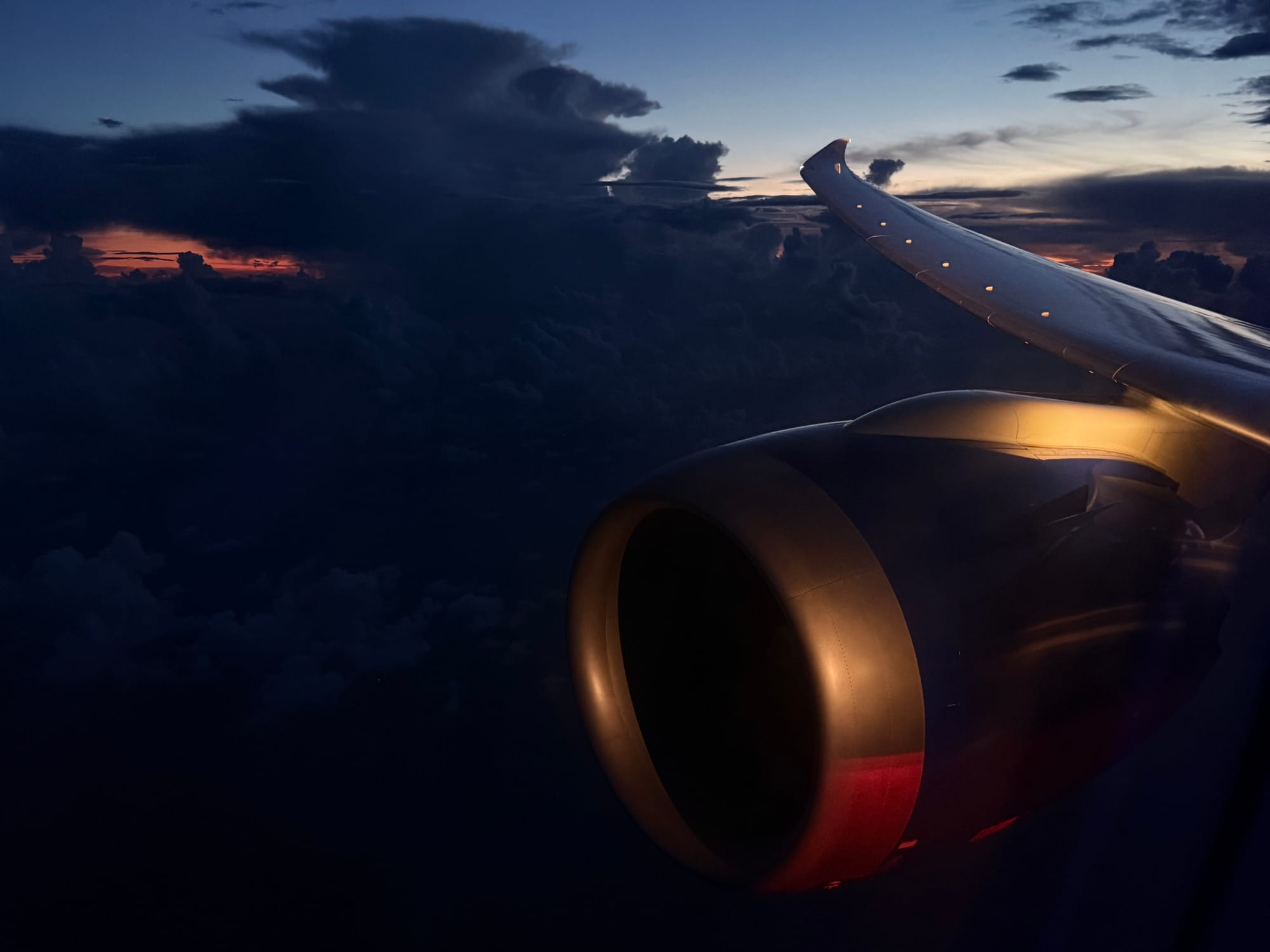 United 787-9 wing and engine over the Pacific at dusk