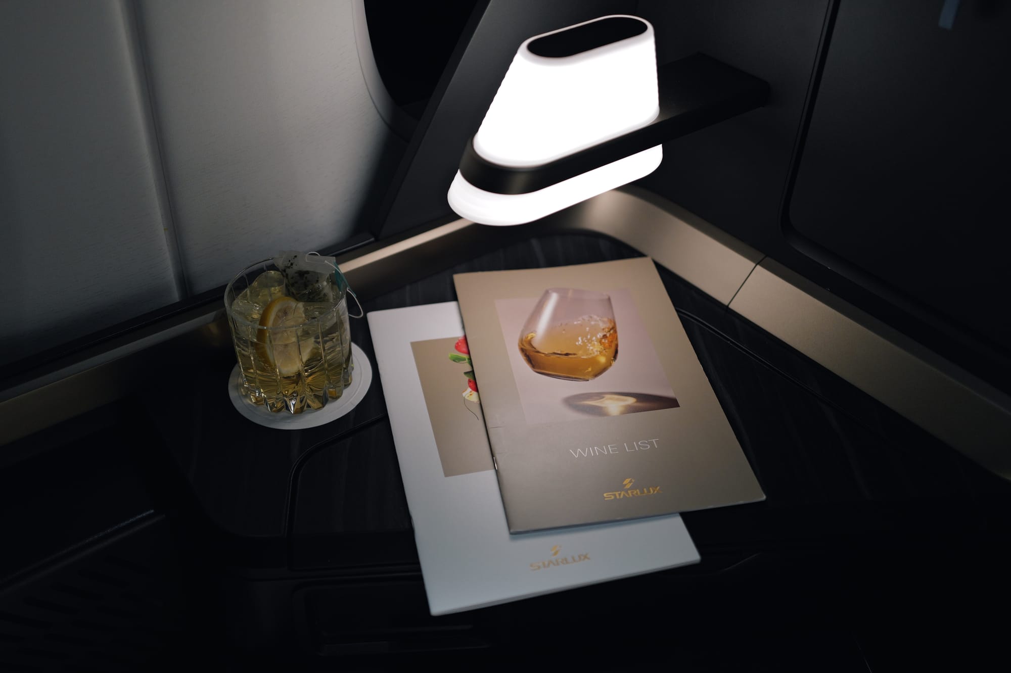 Made-to-order cocktail under the reading lamp in STARLUX business class